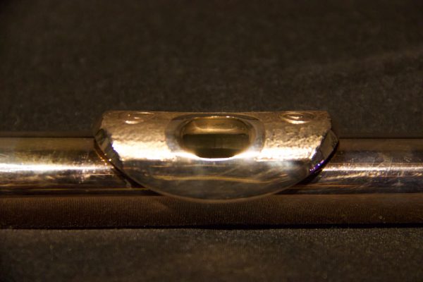 Detailed shot of embouchure hole with gold-plated engraved lip plate