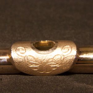 Close-up of ornate engraving design on gold-plated lip plate