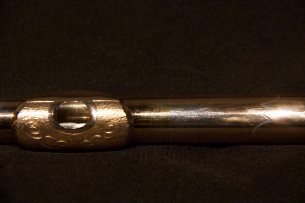 Diagonal angle showing lip plate engraving on gold-plated Jeff Weissman headjoint