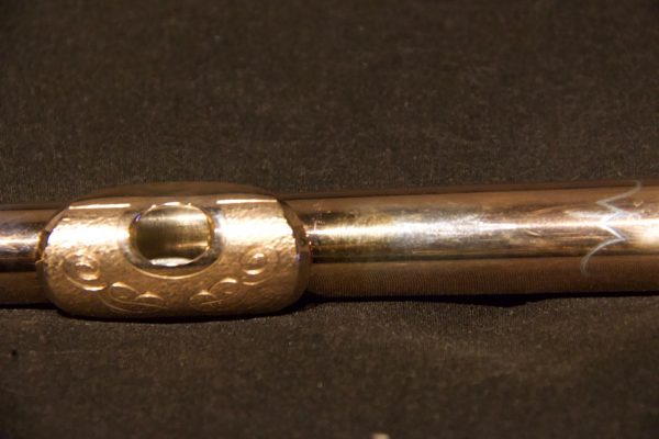 Side view highlighting gold-plated lip plate engraving on Jeff Weissman silver flute headjoint