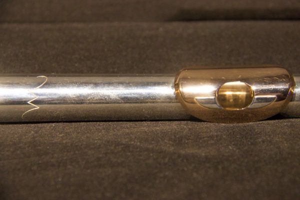 Close-up of Weissman McKenna flute headjoint showing silver body and gold lip plate