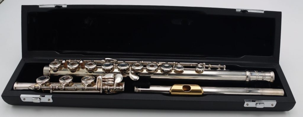 Jupiter intermediate open-hole flute with silver headjoint and gold-tone lip plate resting in an open black hard case.
